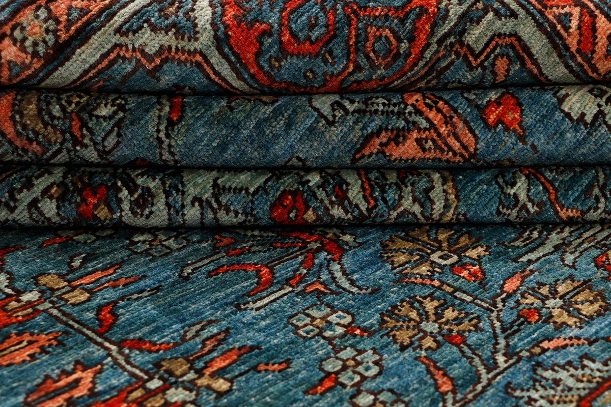 Close-up of blue patterned rug pile with woven orange and dark accents