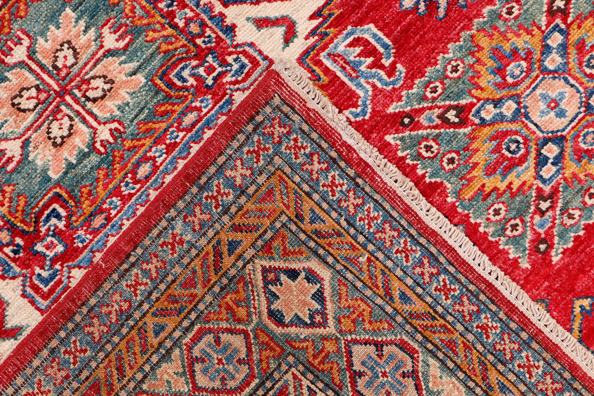 Red Kazak rug with central chevron and diamond pattern in blue and cream