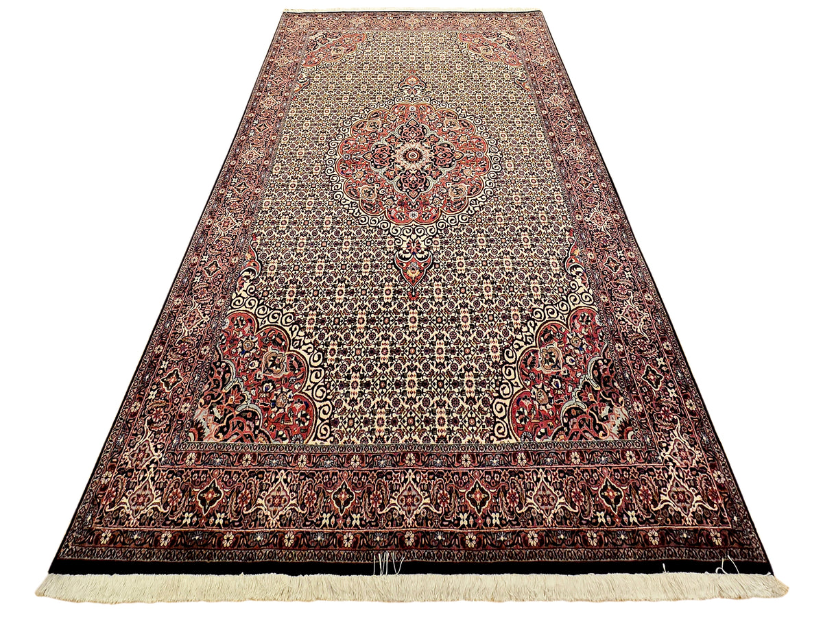 Bidjar rug with red and cream field, ornate border, and cream fringe