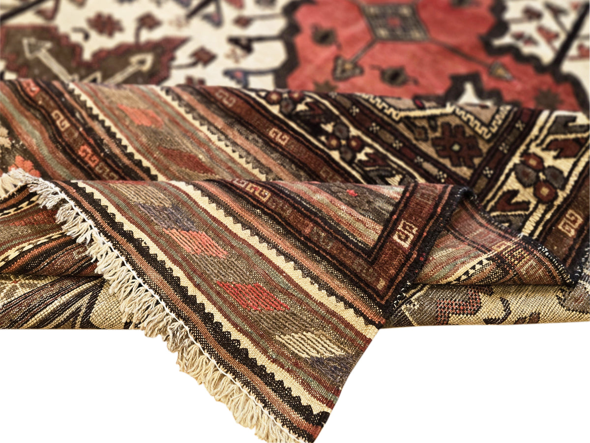 Soumak rug corner close-up with fringe and layered geometric stripes in red, cream, and brown