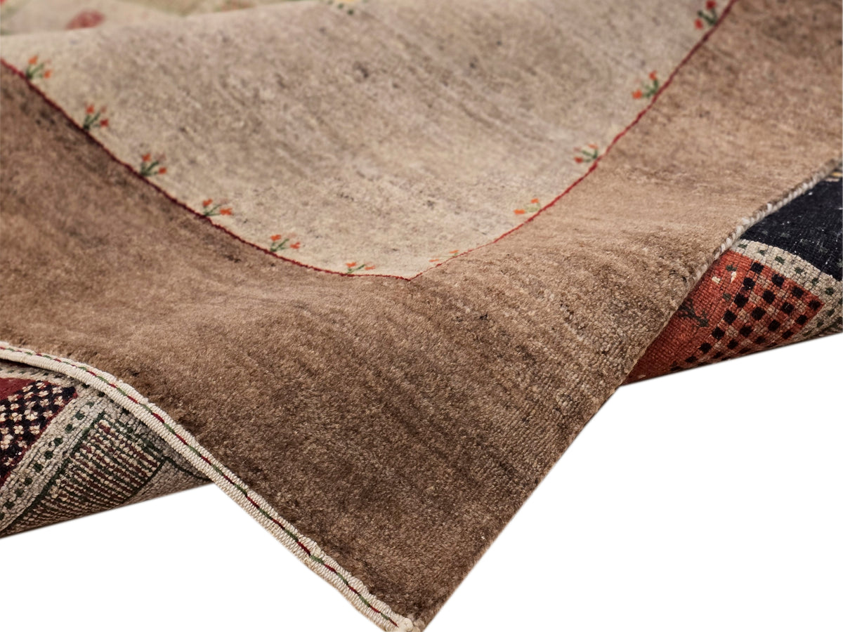 Loribaft rug corner detail, textured beige pile with stitched edge and warm tones