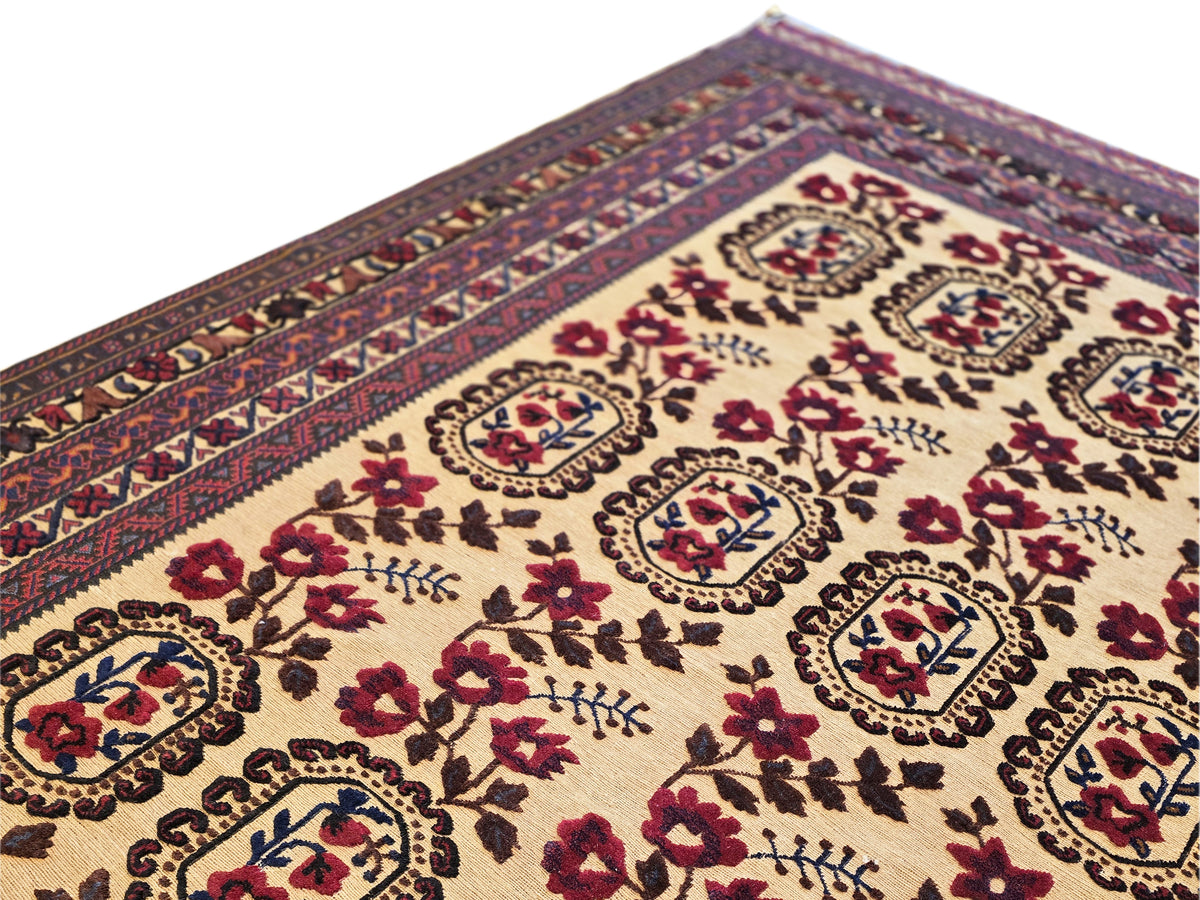 Close-up of cream rug panel with burgundy floral details and navy framed medallions.