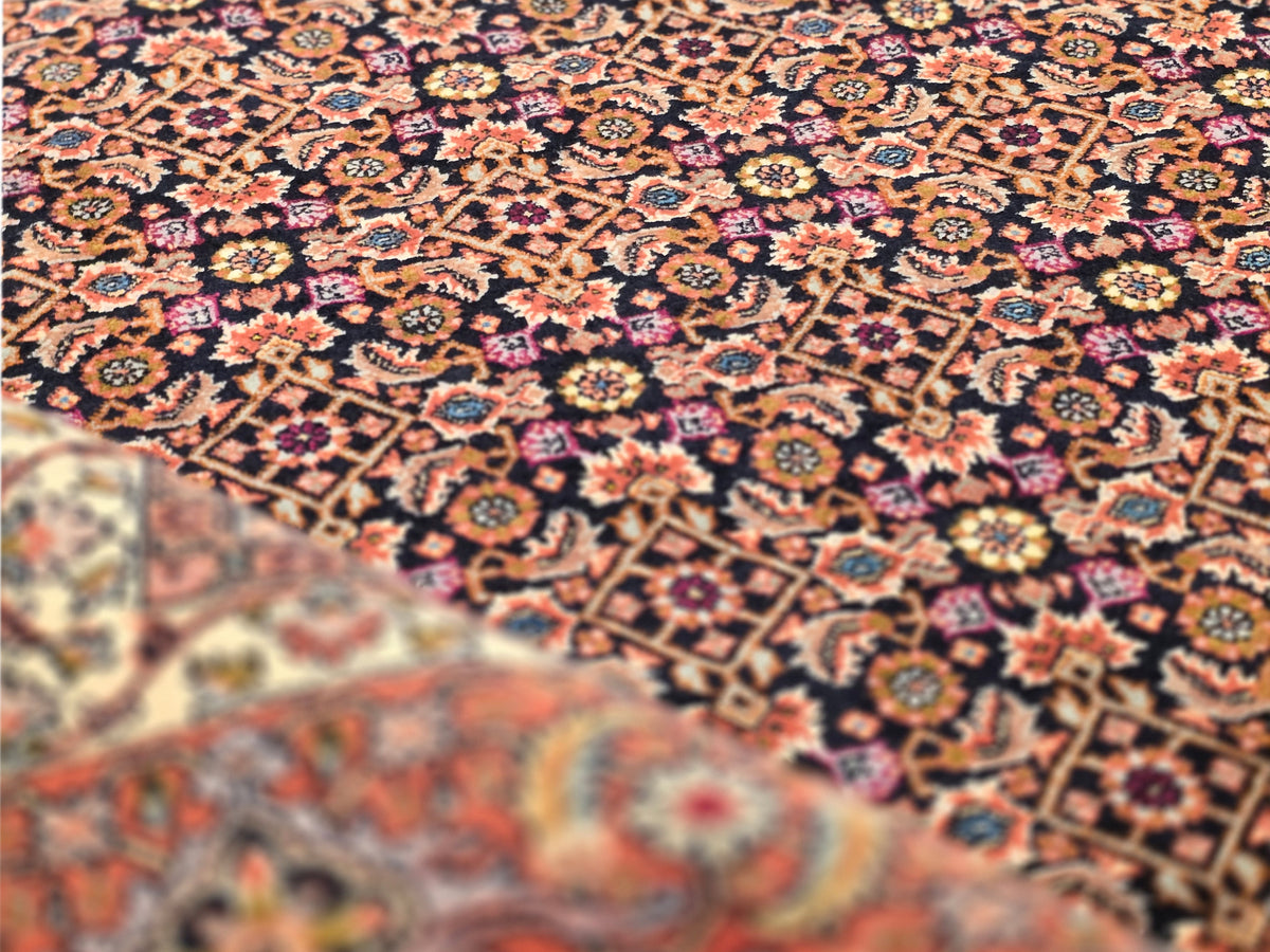 Woven area rug with dark red, navy, and tan geometric motifs