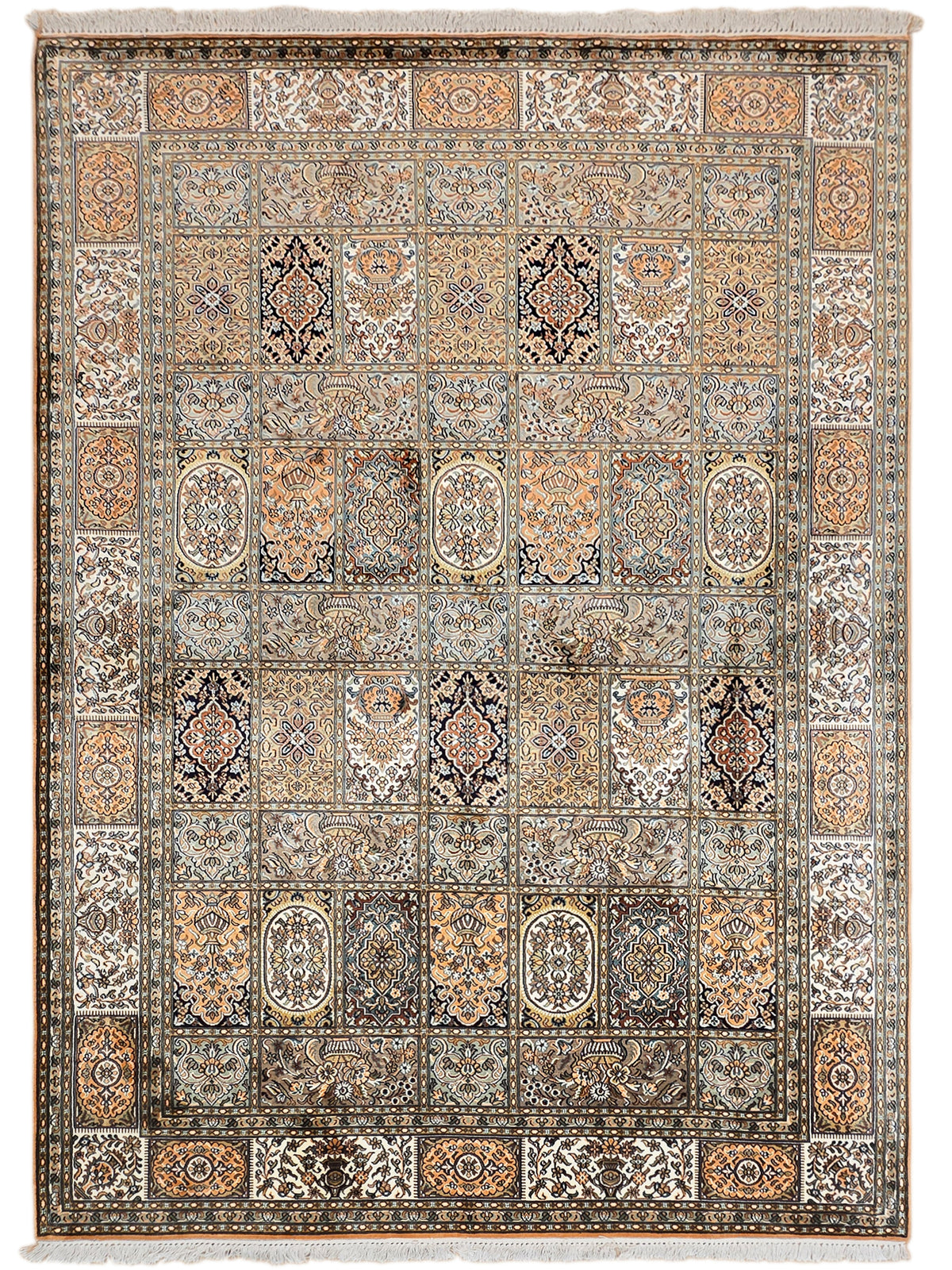 Silk rug with repeating medallions and border, blue and rust tones, fringed edges.
