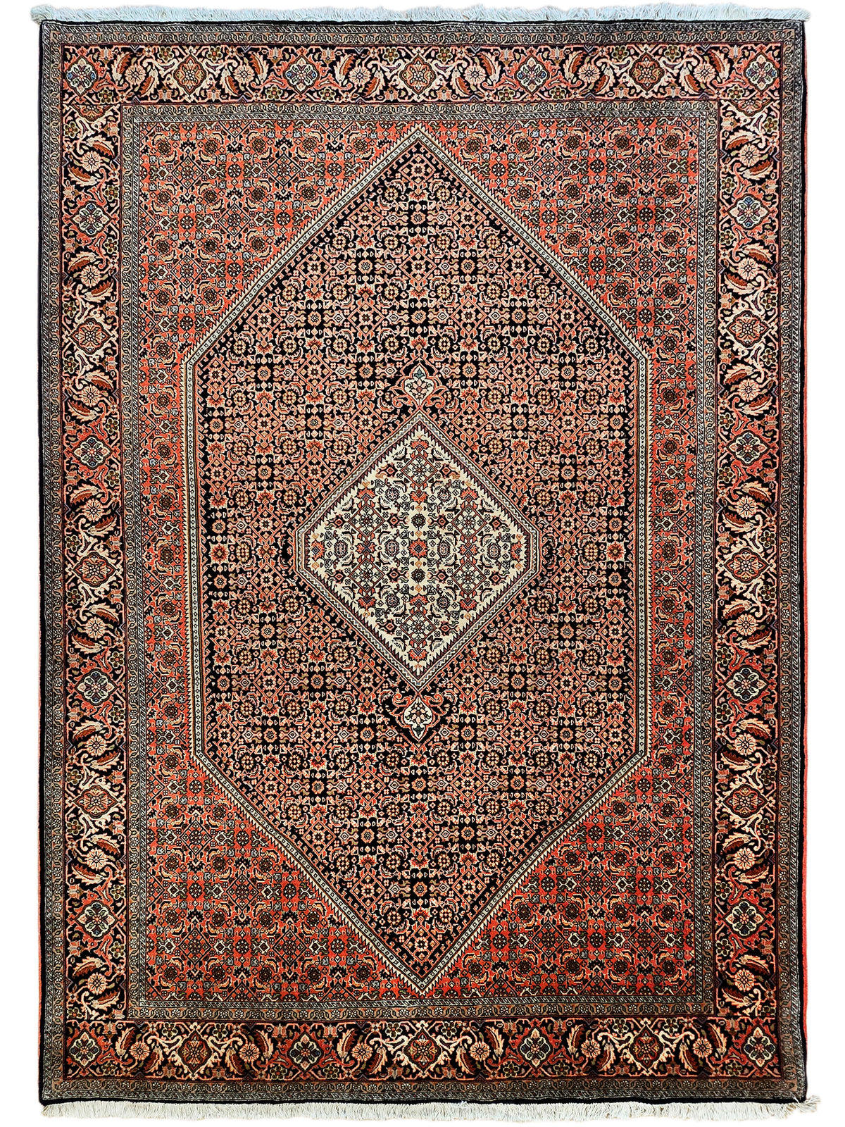 Ornate rust, black and cream area rug with central diamond medallion and bordered design.