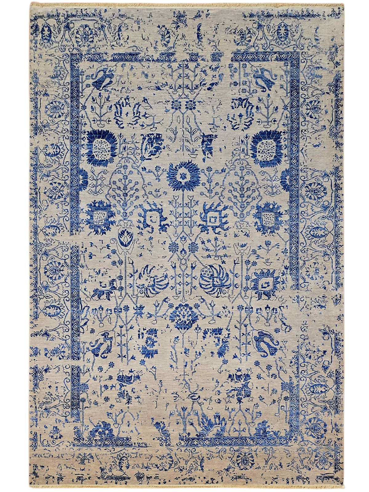 Blue and cream distressed patterned area rug with ornate medallion border