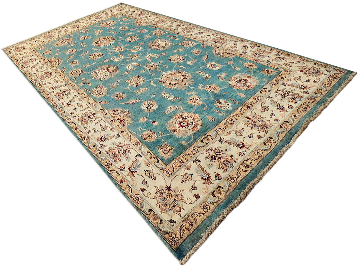 Turquoise rectangular rug with ivory floral medallions and decorative border, fringed ends