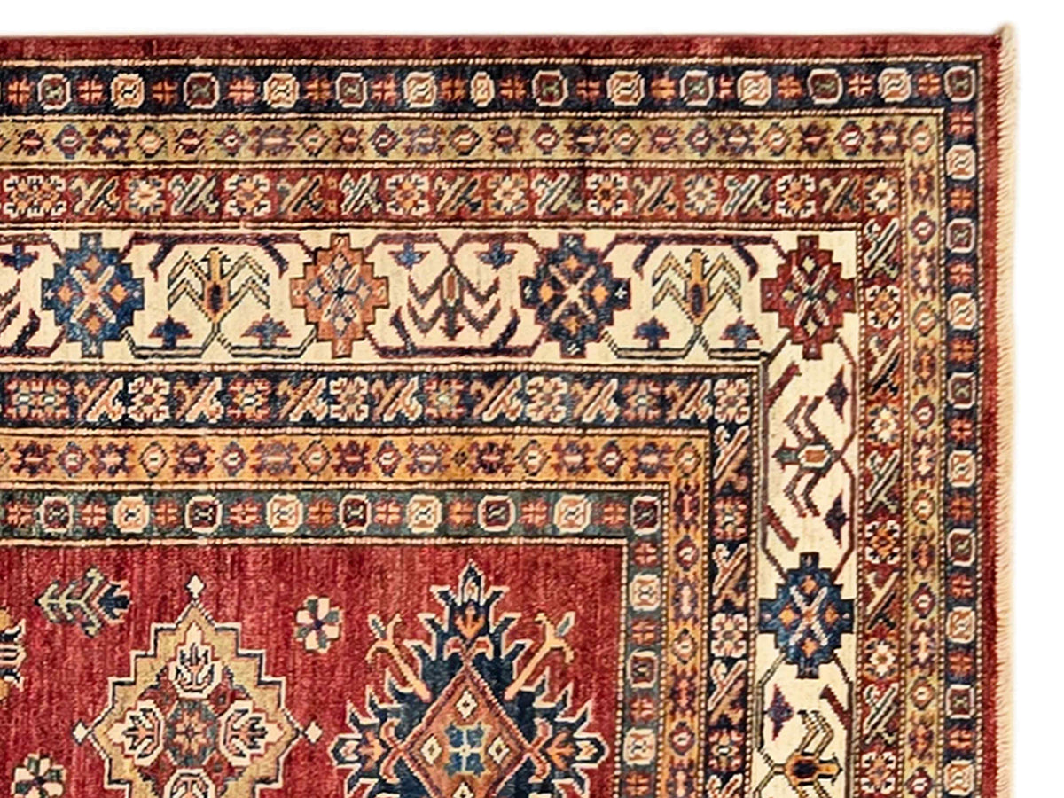 Red and cream rug border with geometric motifs and blue diamond accents