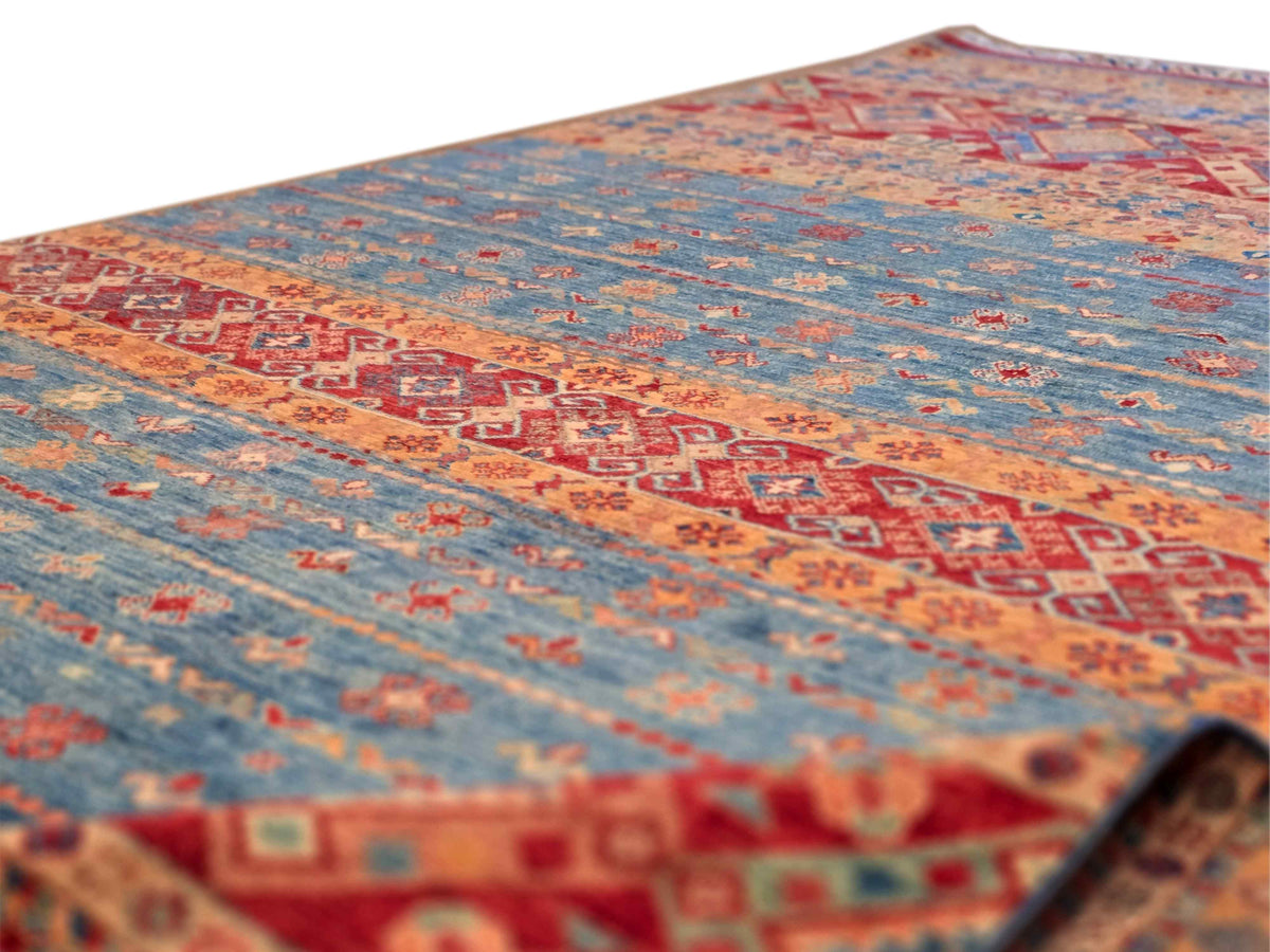 Khorjin-style rug close-up showing textured pile and red-and-blue geometric motifs.