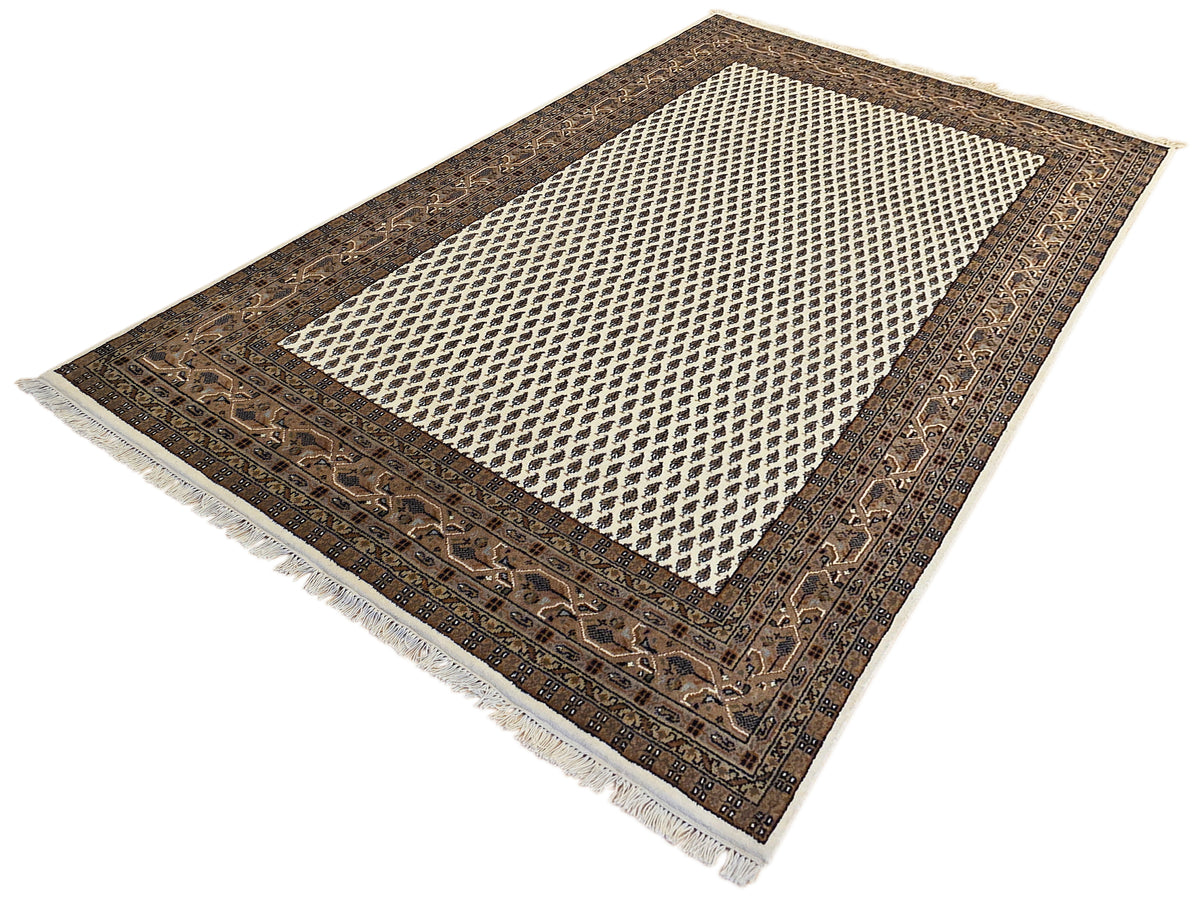 Fringed rug with dark brown geometric border and cream lattice center