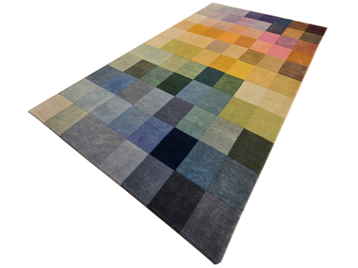 Rectangular rug with multicolor square patchwork in mustard, green, blue, and gray