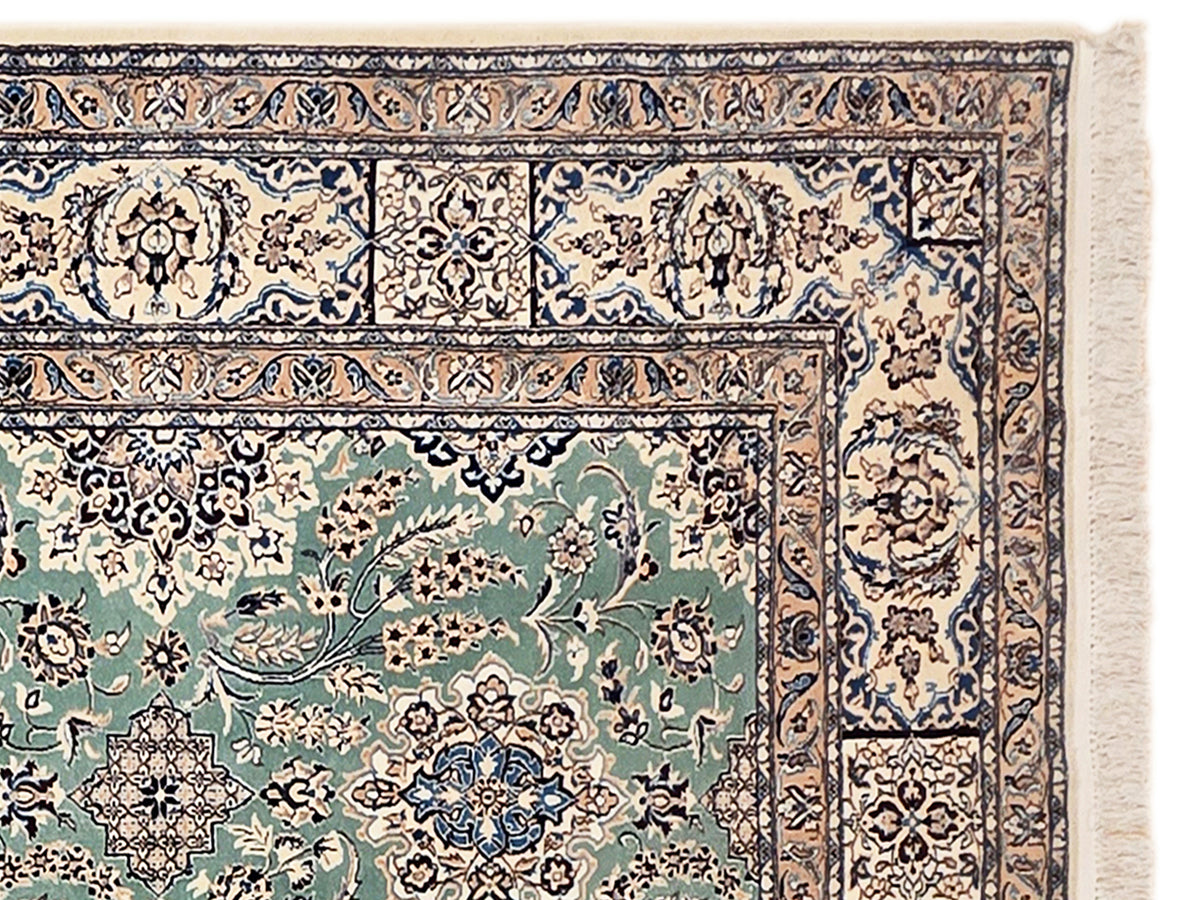 Nain rug border detail with cream, teal, and navy scrollwork plus off-white fringe
