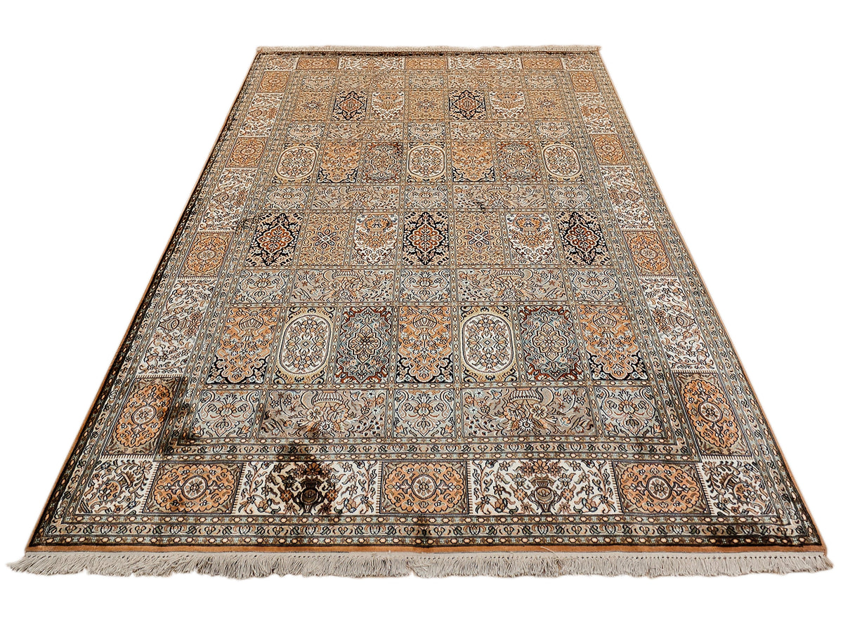Silk rug with central ornament band, warm orange-brown and beige palette, fringe border.