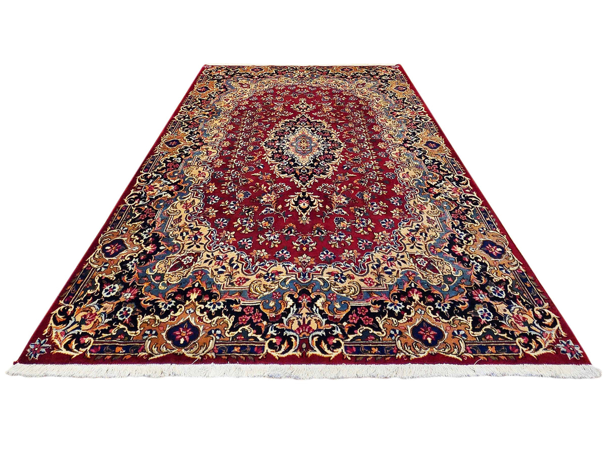 Full view red patterned rug with central medallion and decorative border
