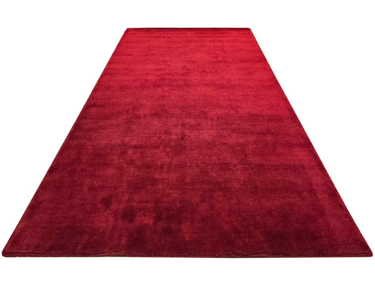 Rectangular red area rug, flat view, smooth edges with low-pile textured surface