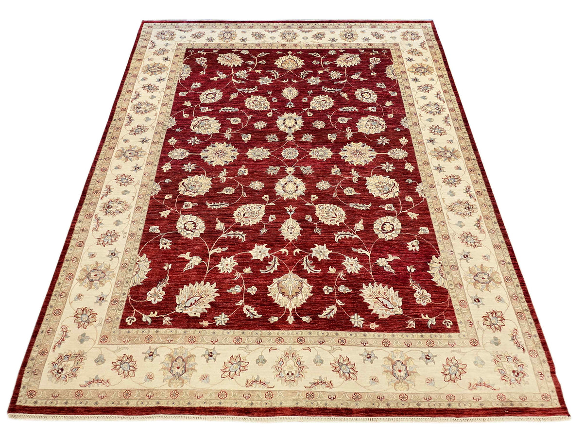 Rectangular red floral area rug with cream border and central ornate medallion