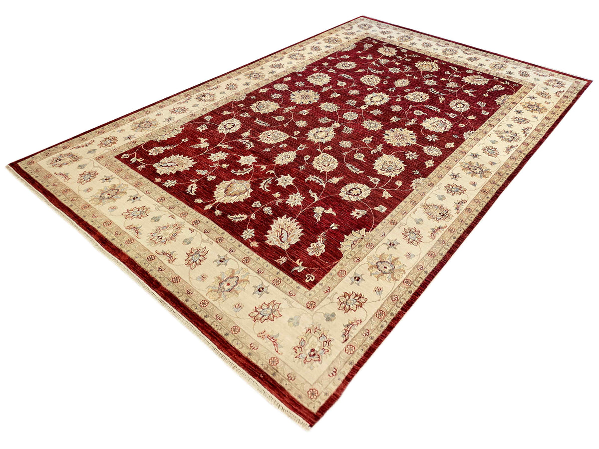Decorative floral area rug with burgundy red field, cream border, and corner medallion