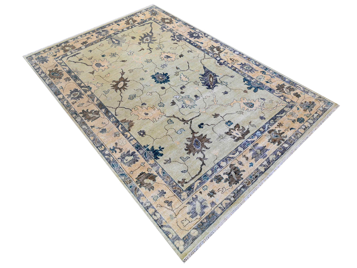 Oushak rug with cream field, blue floral center panel, and decorative side borders