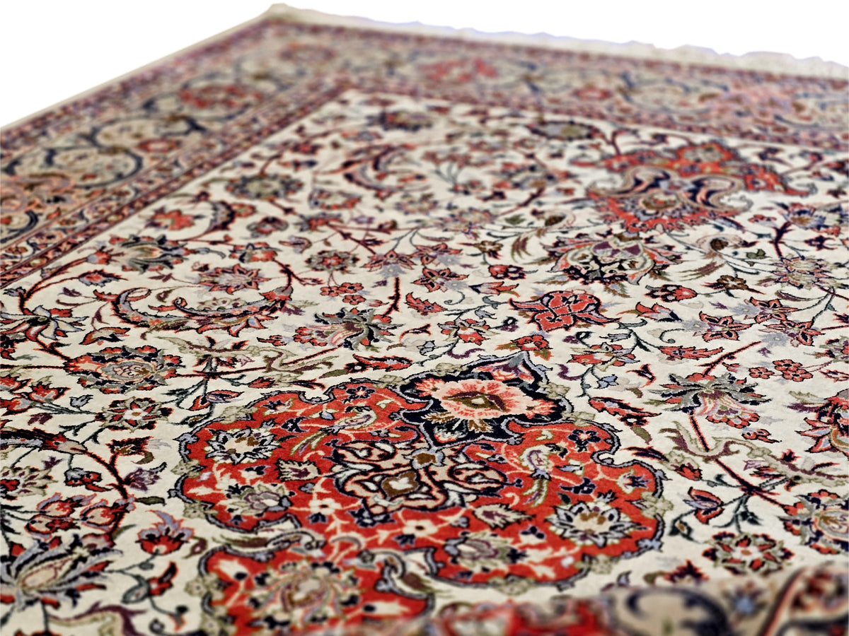 Esfahan perizisch rug with cream field, red central design, and blue ornamental pattern