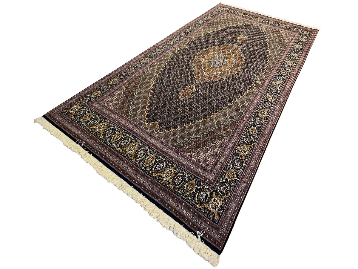 Dark rug with central oval medallion, ornate border, and cream fringed ends