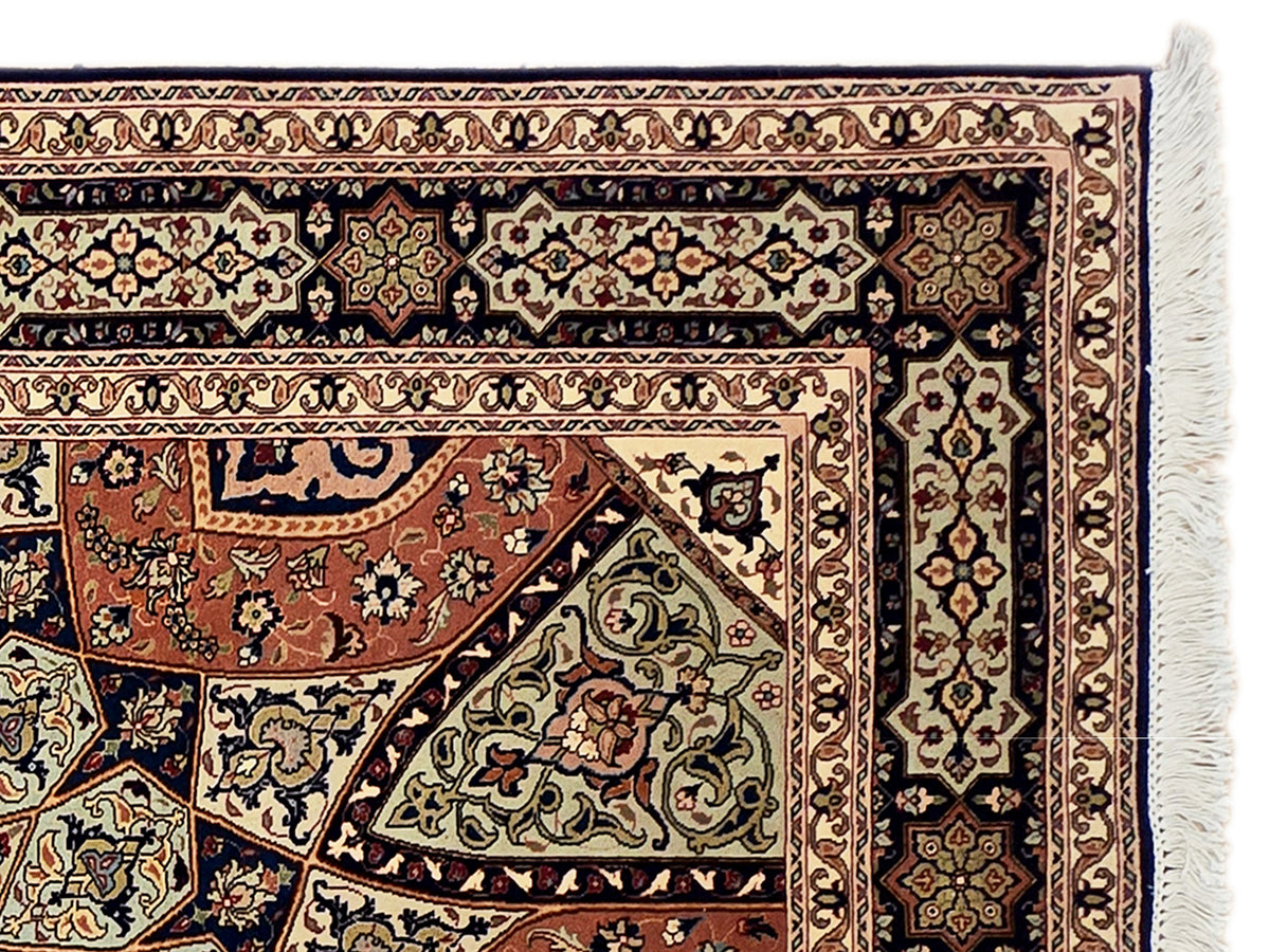 Close-up of Tabriz rug border with navy, cream, and rust medallion details