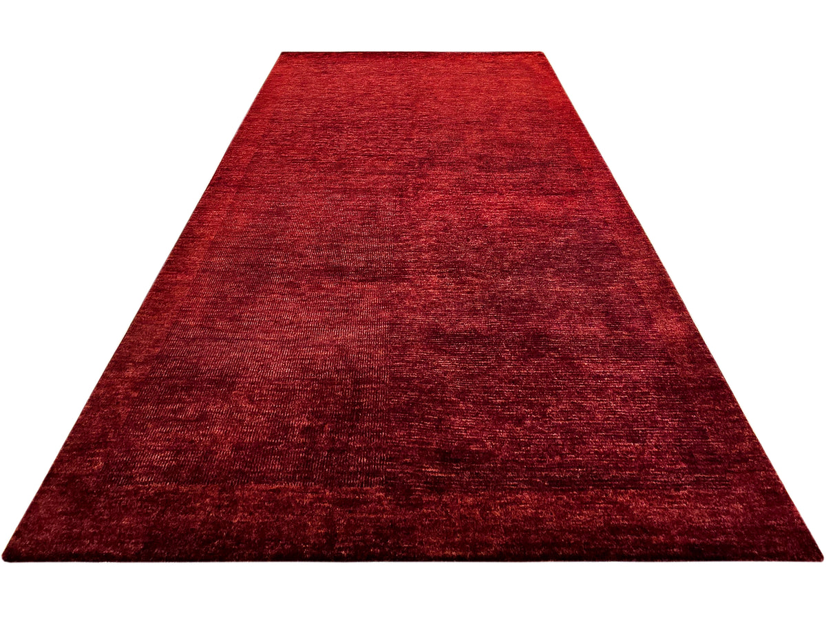 Red area rug with abstract textured surface, trapezoid angled view
