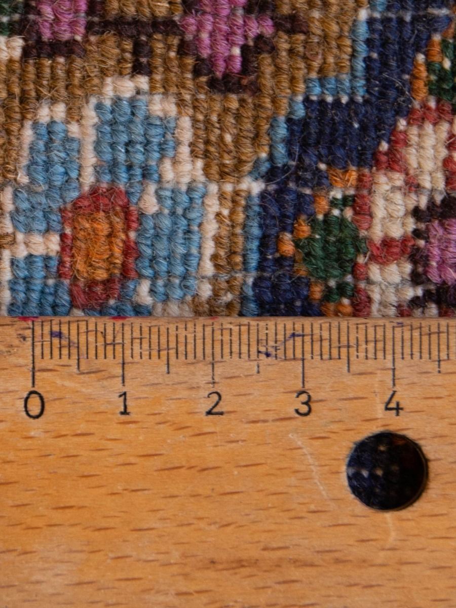 Moud rug close-up of multicolor geometric pile, with ruler for scale
