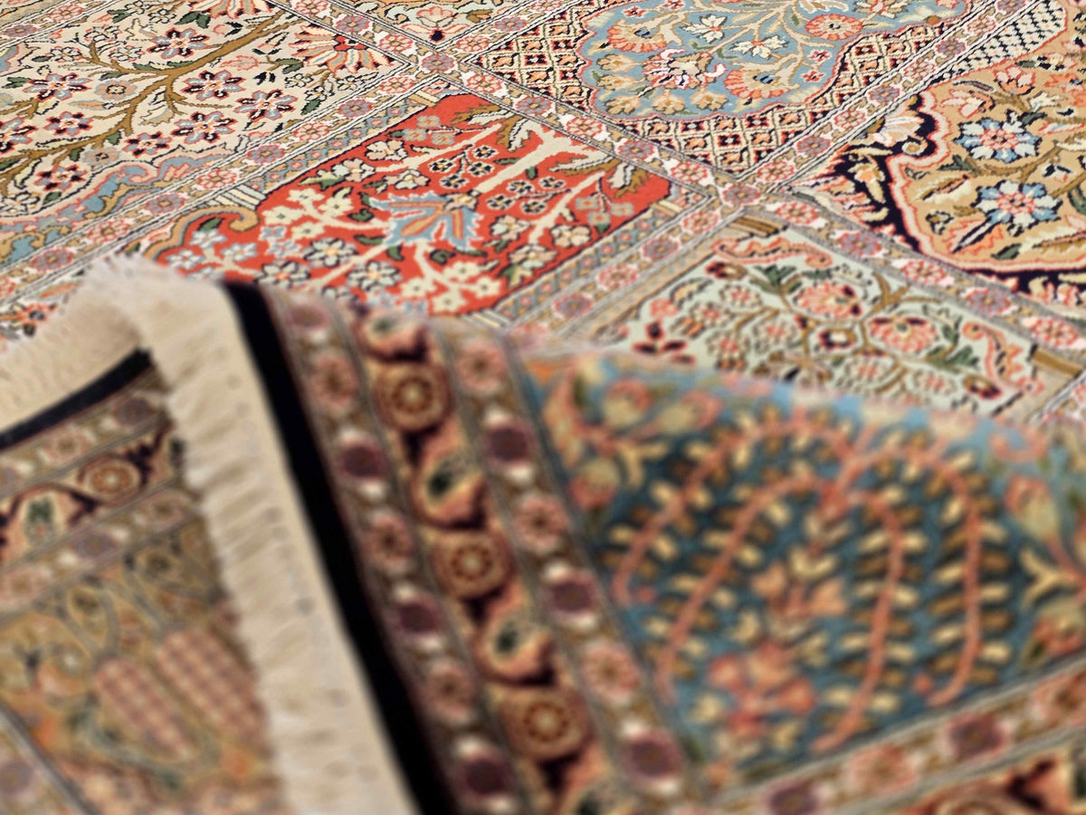 Multicolor ornate rug close-up with decorative motifs and short fringe edge.