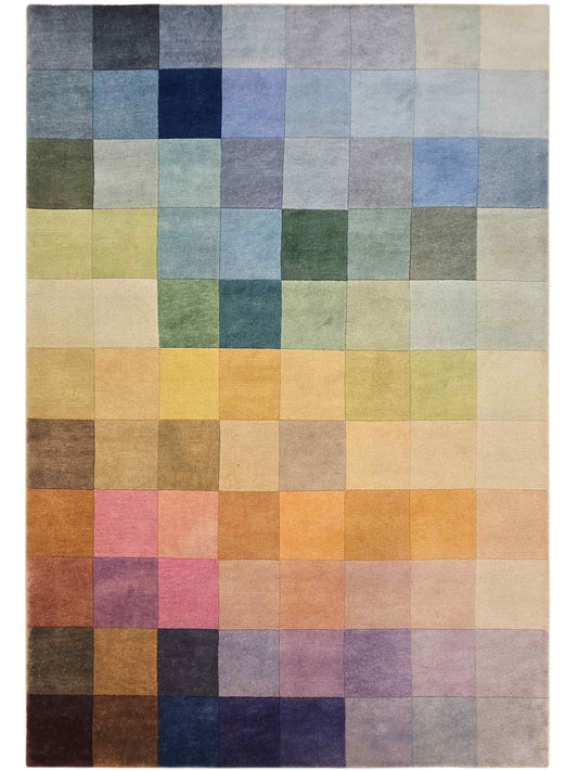 Square patchwork rug with muted rainbow blocks in gray, cream, blue, and green