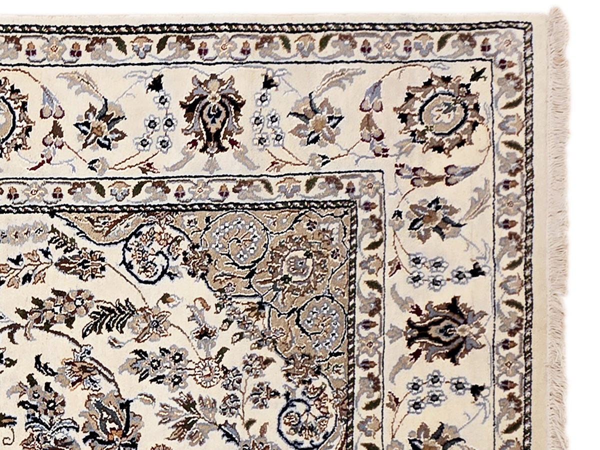 Nain rug with ivory field and dark navy floral medallion border, short fringed edge