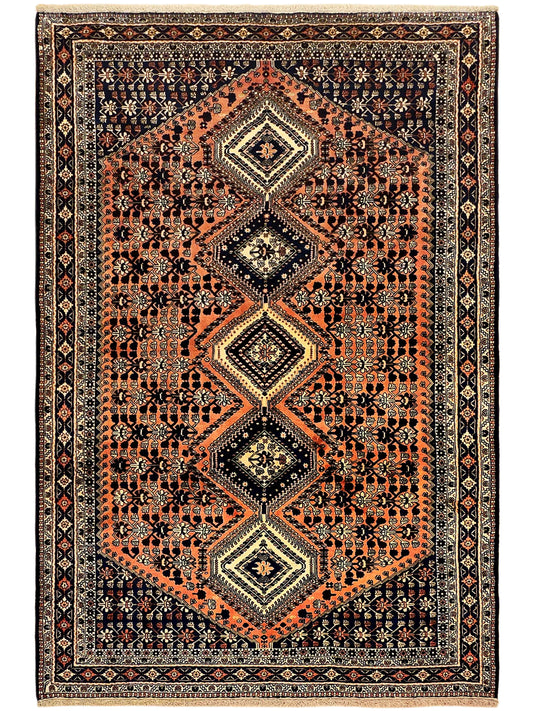 Rectangular orange and dark navy area rug with diamond medallion, ornate border pattern