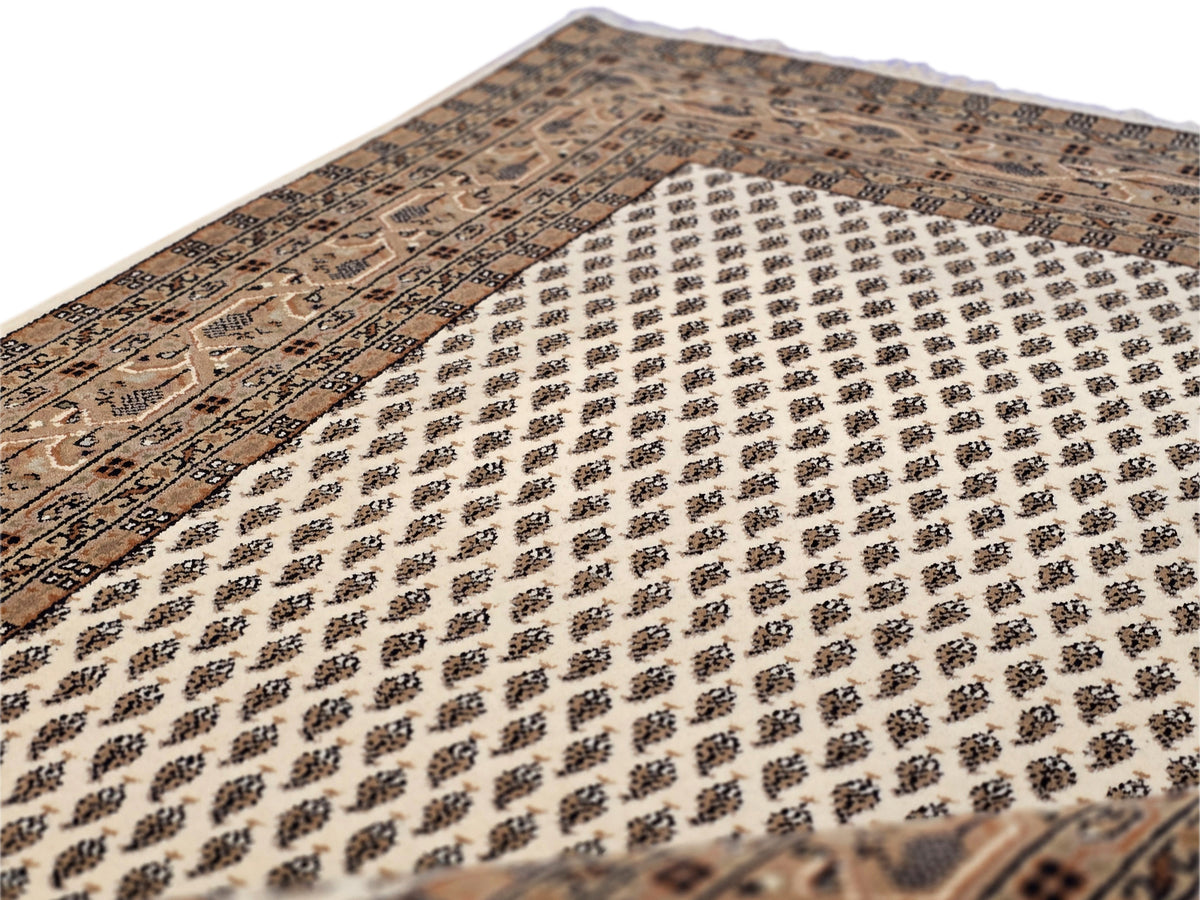 Close-up of white lattice pattern rug with dark ornamental border sections