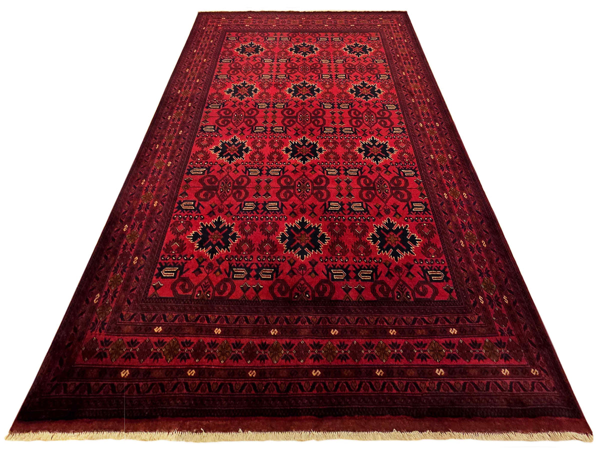 Red patterned area rug with bordered medallion, low pile and fringed edges