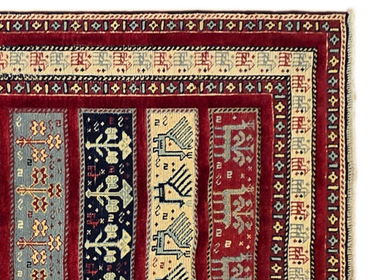 Close-up rug section with red, cream, navy, and gold ornamental bands