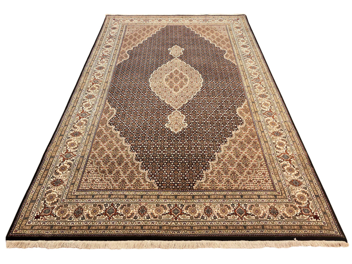 Fringed Tabriz mahi rug with brown center panel, cream motifs, and corner ornaments