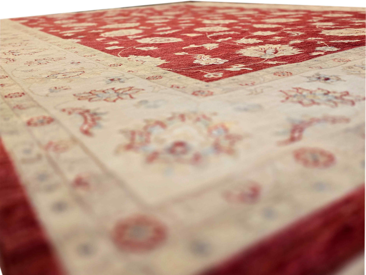 Close-up of red floral area rug with cream pattern and border