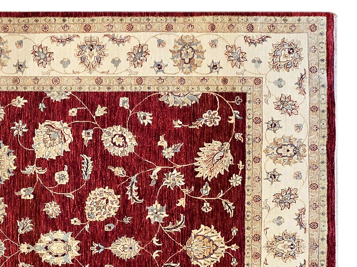 Close-up of burgundy floral rug panel with cream vine border and detailed corner edging