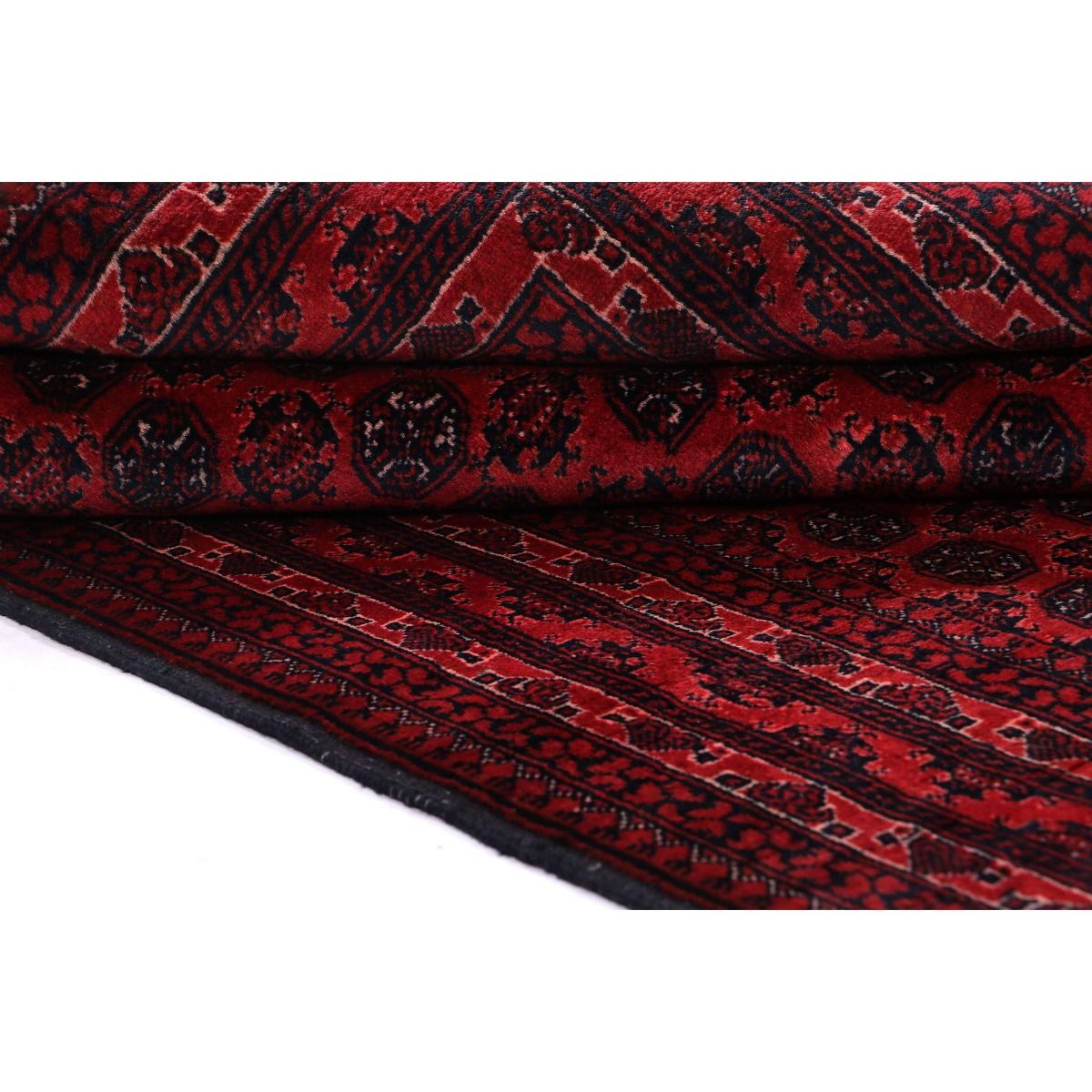 Folded red Bukhara rug with patterned border and short fringed edge