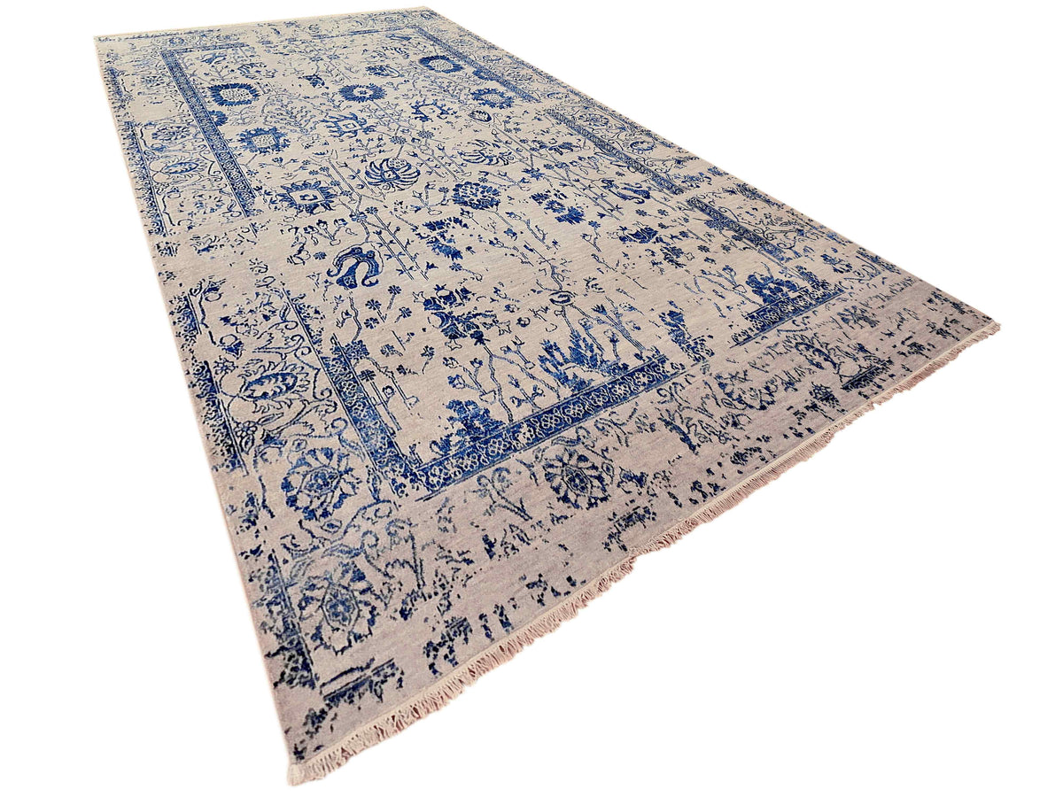 Blue and cream vintage-style patterned area rug with fringed border