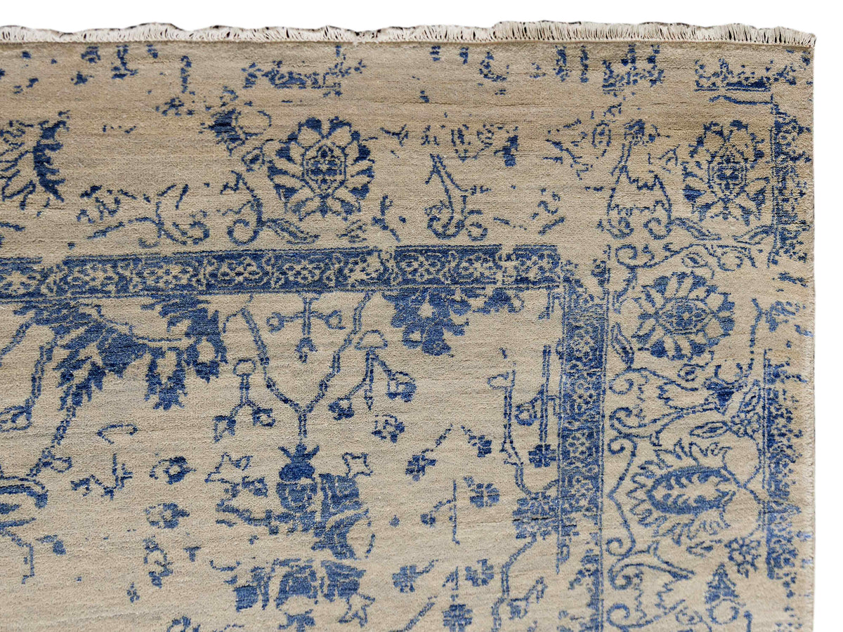 Beige and blue patterned area rug with fringe border, corner close-up detail.
