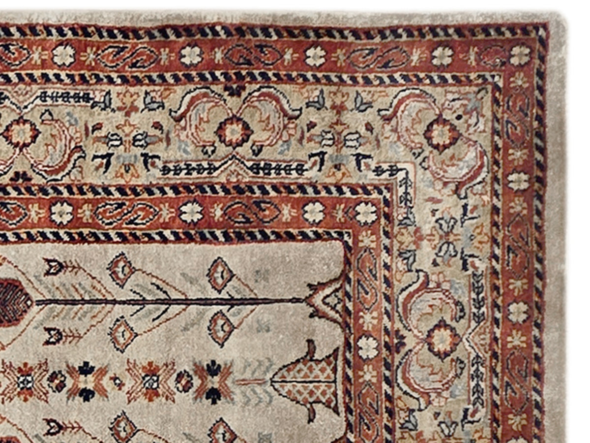 Rectangular rug with cream field and red navy patterned border details