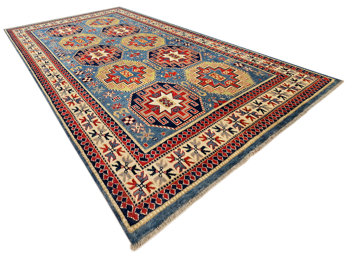Kazak rug with blue field, red outlined medallions, cream accents, and dark border.